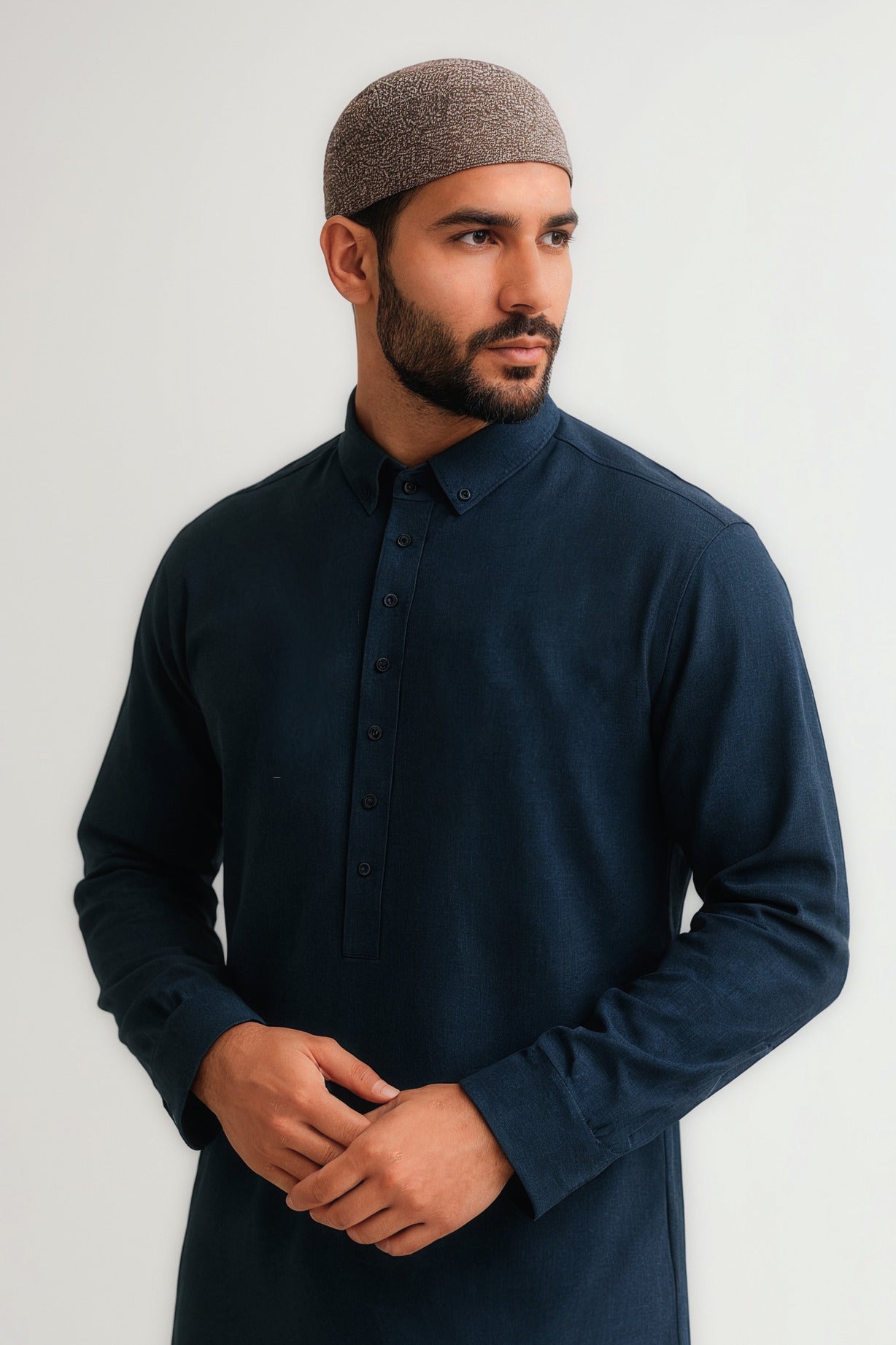 Man wearing a dark blue shirt and brown cap against a white background