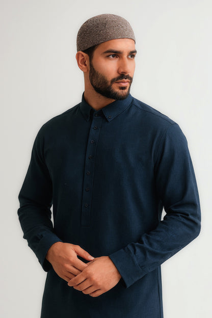 Man wearing a dark blue shirt and brown cap against a white background