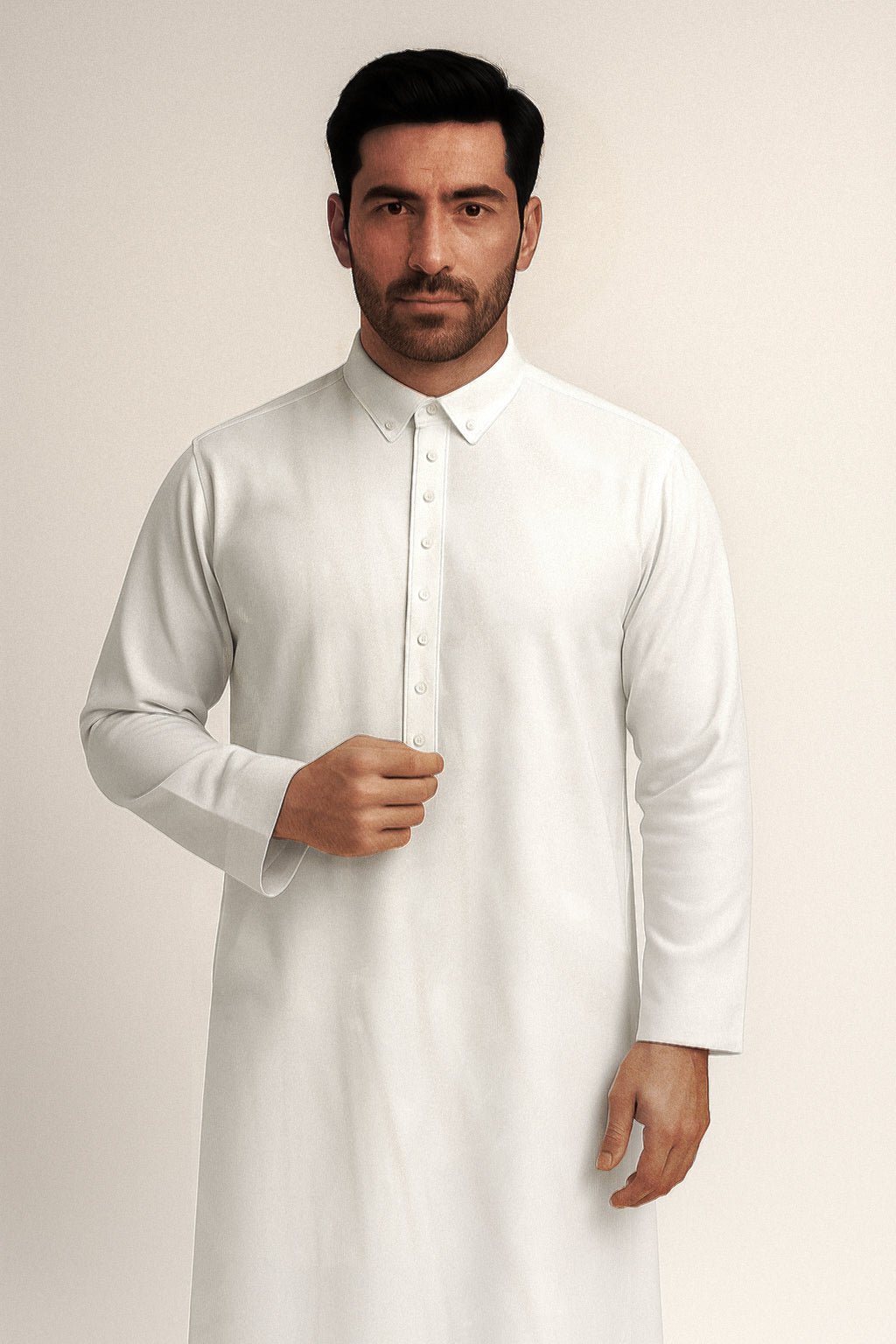 Man wearing a white Thawb against a plain background